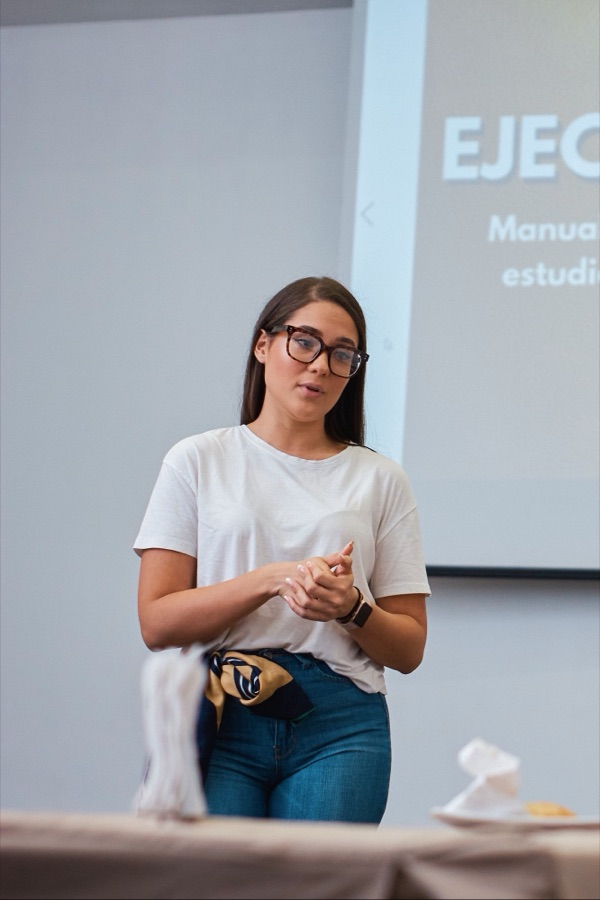 Victoria explicando la fase de ejecución de un proyecto frente a una pantalla